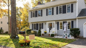 Painter refreshing the exterior of a Connecticut home before selling, with ladder, drop cloths and paint cans
